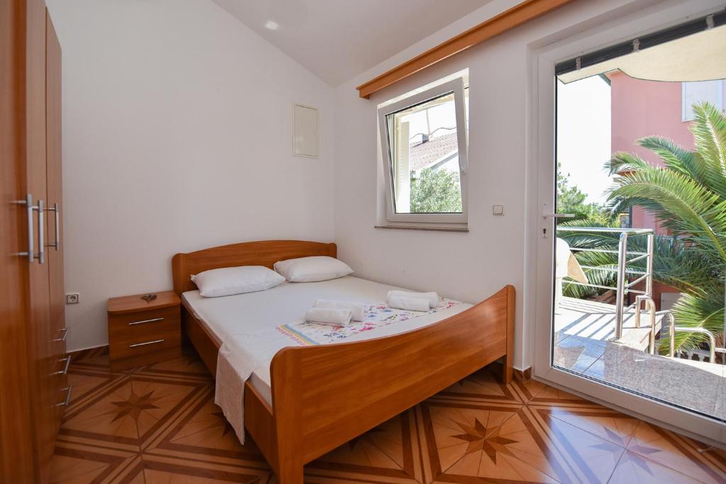 ein Schlafzimmer mit einem Bett und einem großen Fenster in der Unterkunft Apartments Bella Sky III/IV in Novalja
