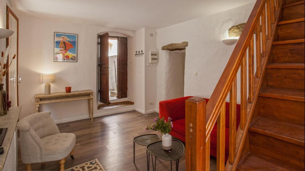 - un salon avec un escalier et une chaise rouge dans l'établissement Casa Anto - Au coeur de Calenzana, à Calenzana