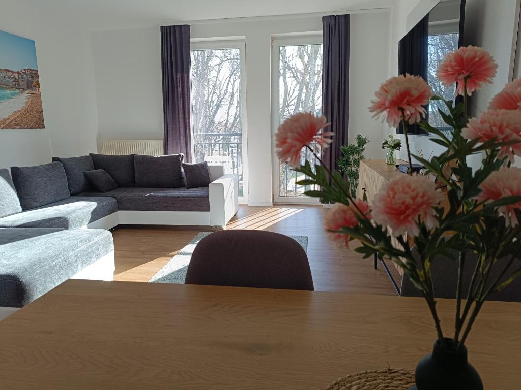 a living room with a vase of flowers on a table at Room in the city 2 in Sopron