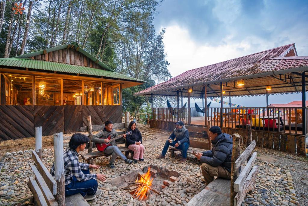 Un groupe de gens assis autour d'un feu dans l'établissement Zostel Rinchenpong (Pelling), à Rinchingpong