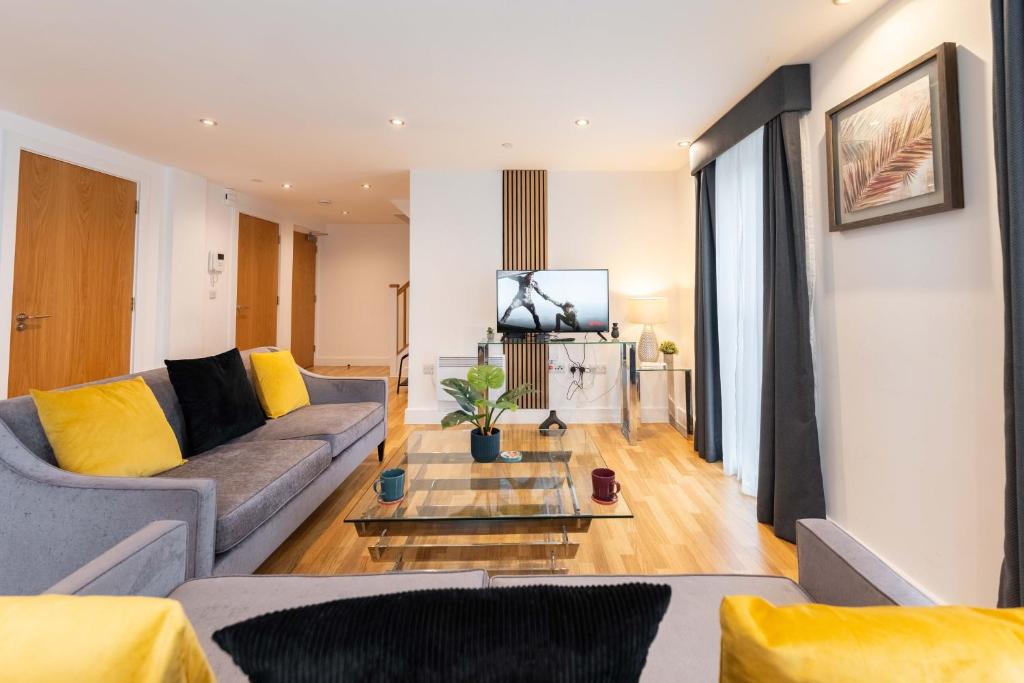 uma sala de estar com um sofá e uma mesa em Leeds City Centre Duplex 3 Bedroom 3 Bath stunning Flat with Rooftop Terrace and Parking em Leeds