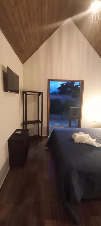 a bedroom with a bed and a large window at Recanto do Sossego in São Sebastião