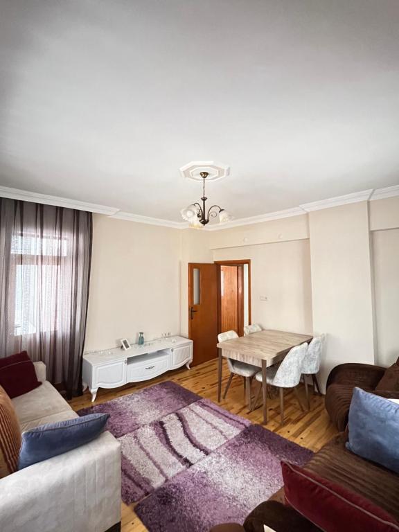 uma sala de estar com um sofá e uma mesa em Konfor ve huzurunuz için her şey var klimasız oda em Antalya