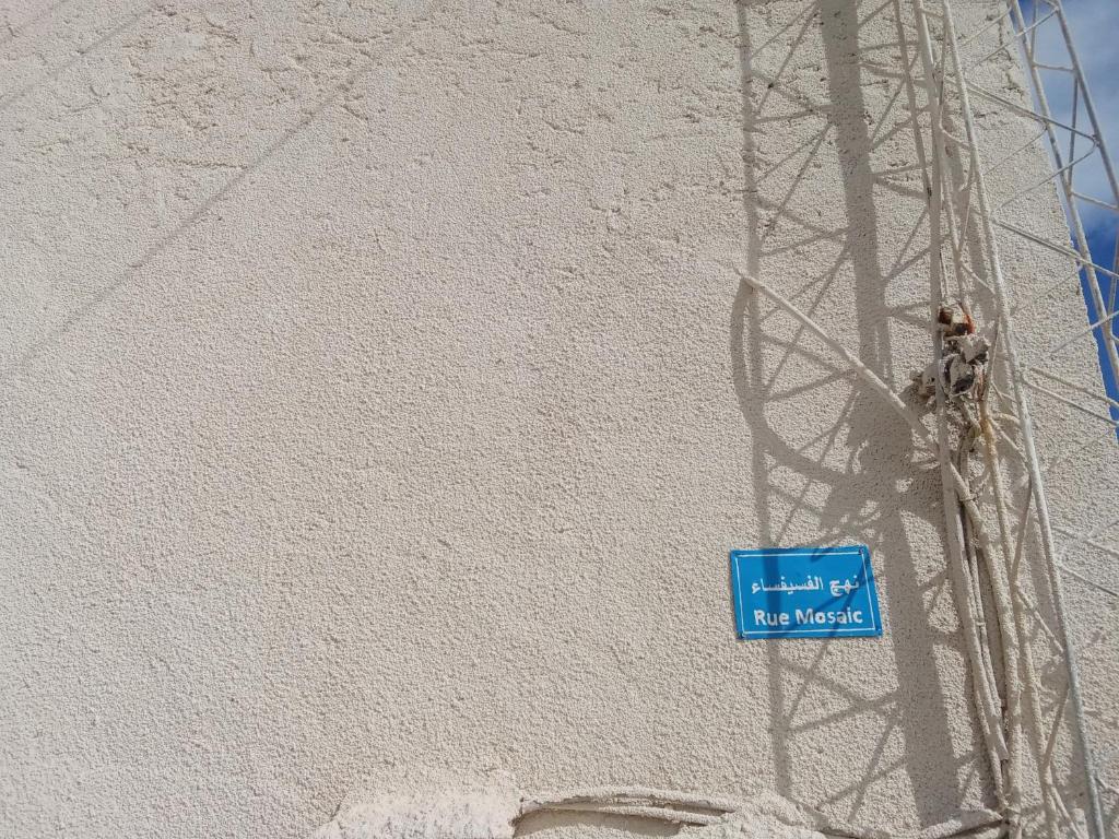 a blue sign on the side of a wall at Venus house15 in Raoued