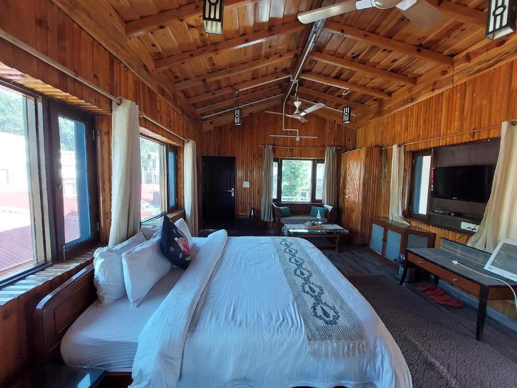 1 dormitorio con 1 cama grande en una cabaña de madera en Alinda House Naukuchiatal by THE GHAUR en Bhīm Tāl