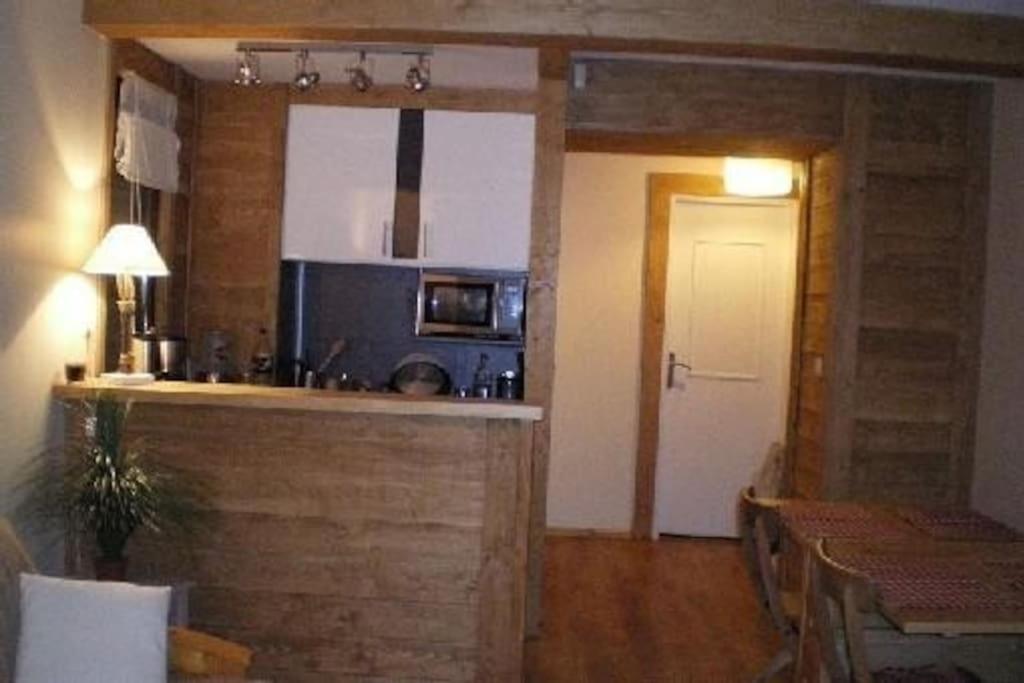une cuisine et une salle à manger avec une table et un comptoir dans l'établissement Appartement 2 pièces au milieu des chalets. Grande Terrasse Orientée Sud, à Saint-Étienne-de-Tinée