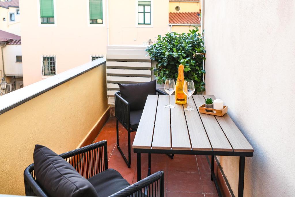 un tavolo con sedie su un balcone con una bottiglia di vino di Naboo Guest House - Amalfi Coast a Salerno