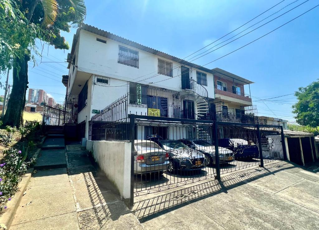 Un edificio con coches aparcados en un estacionamiento. en Hospedaje Santaisa, en Cali