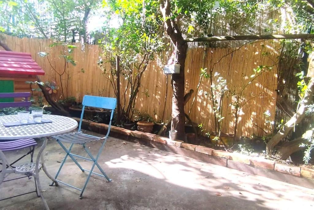 un patio avec une table et des chaises et une clôture dans l'établissement Appartement de charme avec jardin, à Puteaux