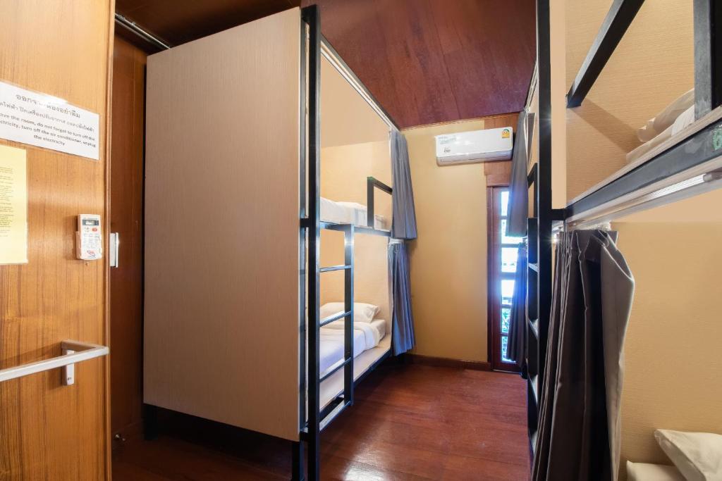 a room with two bunk beds and a hallway at Cozy Hub Hostel in Chiang Mai