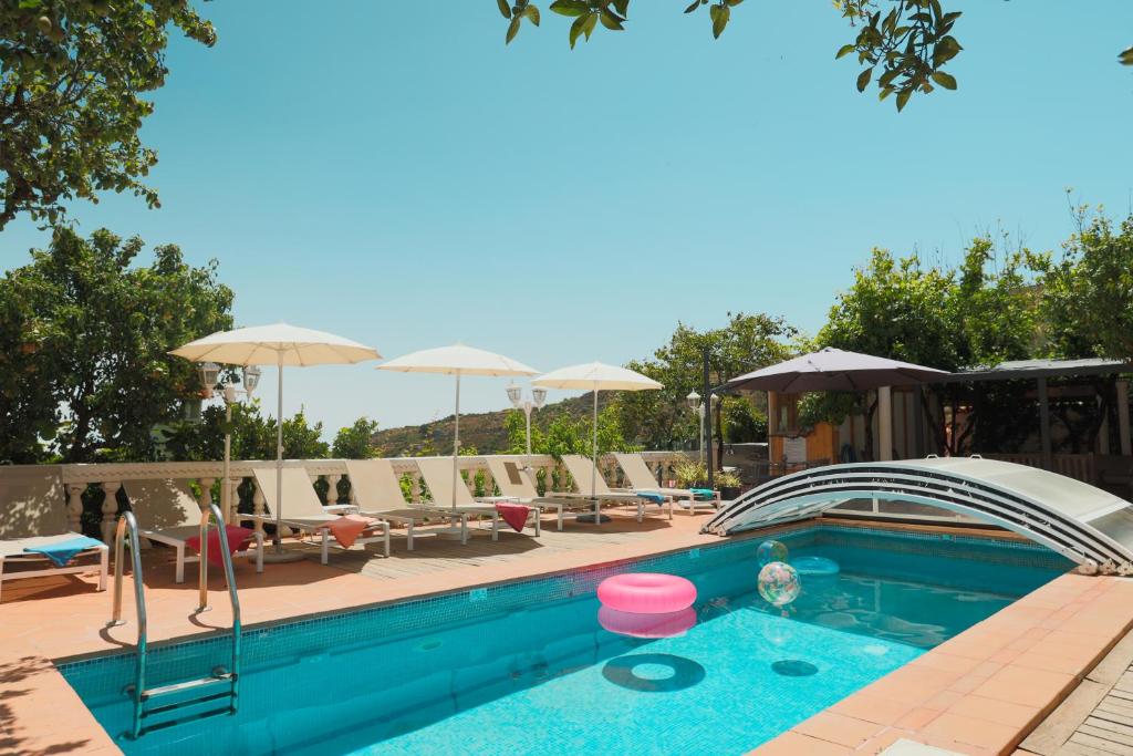 einen Pool mit Liegestühlen und Sonnenschirmen in der Unterkunft El Estanco 14 in Vega de San Mateo