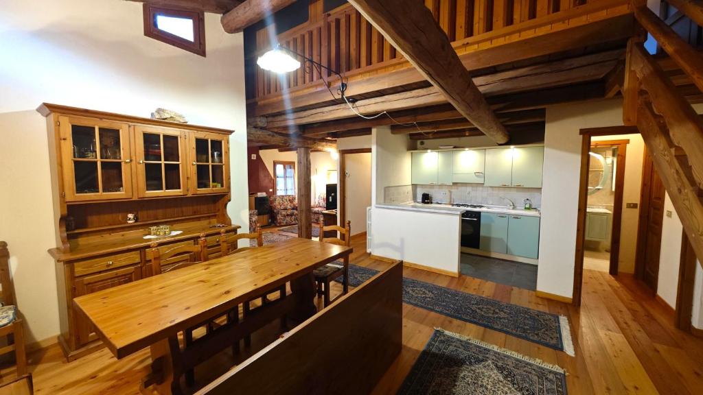 a large kitchen with a wooden table in a room at Hostdomus -Flower Loft in Cesana Torinese
