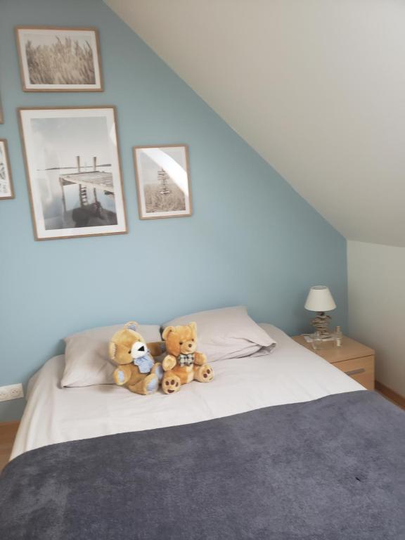 zwei Teddybären auf einem Bett in der Unterkunft CHAMBRE LIT DOUBLE A proximité de Paris in Champagne-sur-Oise
