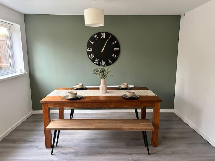 a table with a clock on a wall and a table with a bench at Middlesbrough contractors digs in Middlesbrough