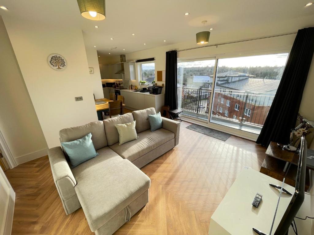 a living room with a couch and a large window at Urban Living with Free Wi-Fi & Parking in Rickmansworth