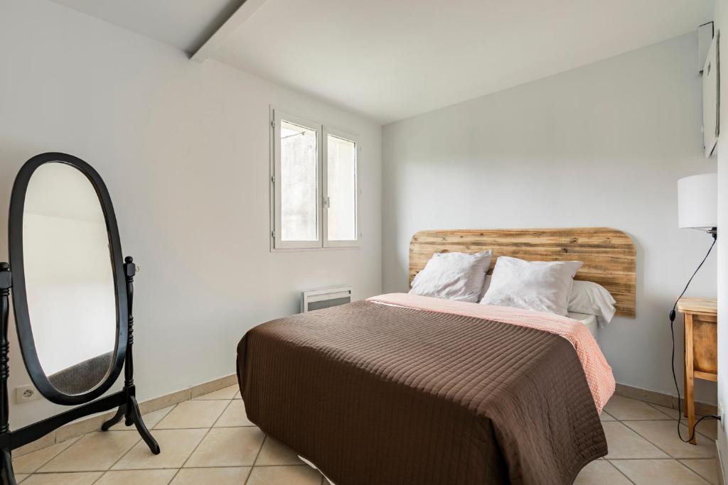 1 dormitorio con cama con espejo y tocador en Maison Arcachonnaise sur Mérignac, en Mérignac