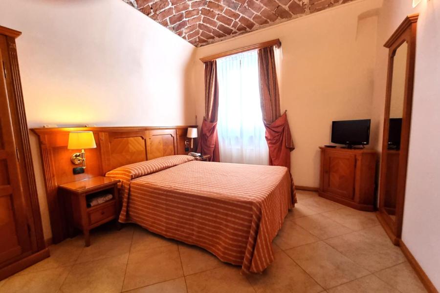 a bedroom with a bed and a window at Hotel Acqui & Centro Benessere in Acqui Terme