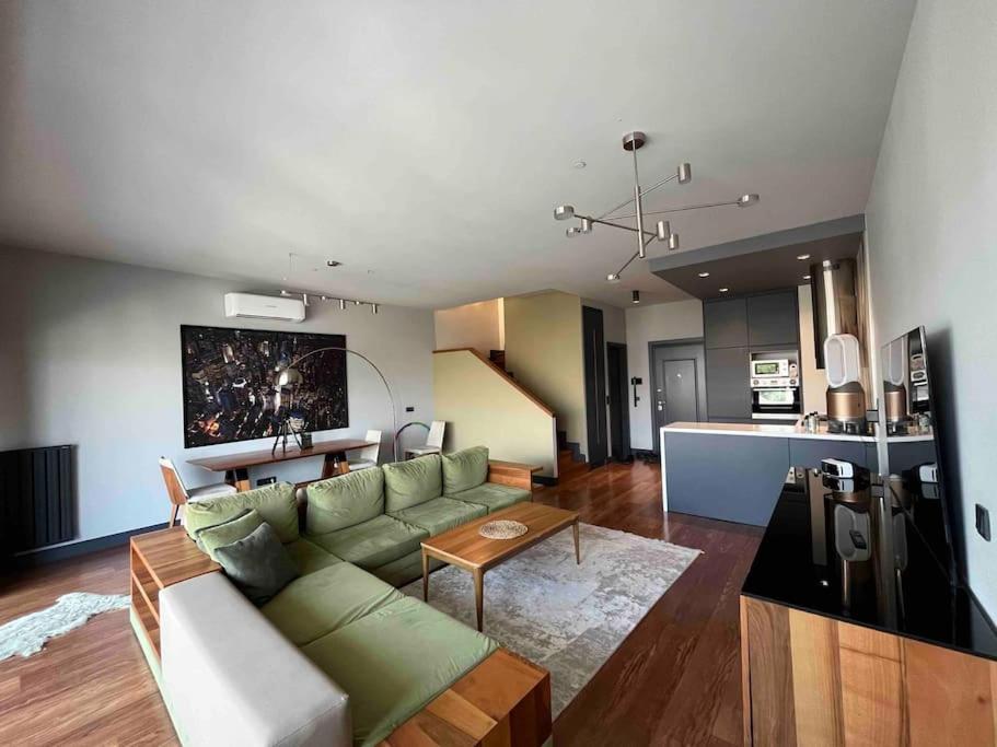 een woonkamer met een groene bank en een keuken bij Modern Penthouse in the Center in Istanbul
