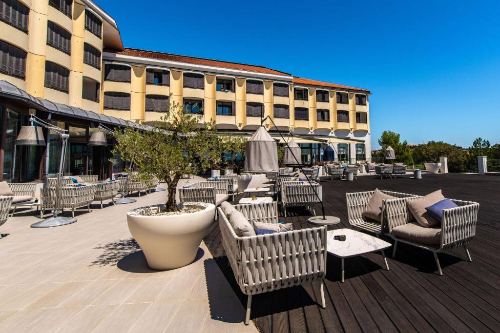 a patio with chairs and tables and a building at Park Plaza Histria Pula in Pula