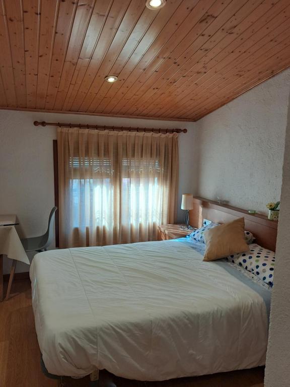 1 dormitorio con 1 cama grande y techo de madera en EVA & TRAVEL - CAL MARCEL - Habitacion, en Prades