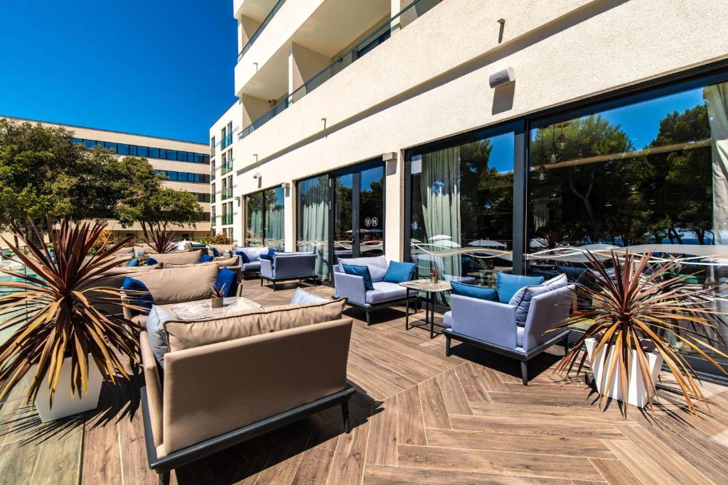 a patio with couches and chairs in front of a building at Park Plaza Arena Pula in Pula