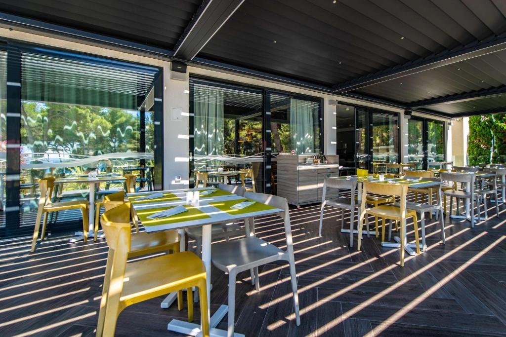 a restaurant with tables and chairs on a deck at Park Plaza Arena Pula in Pula