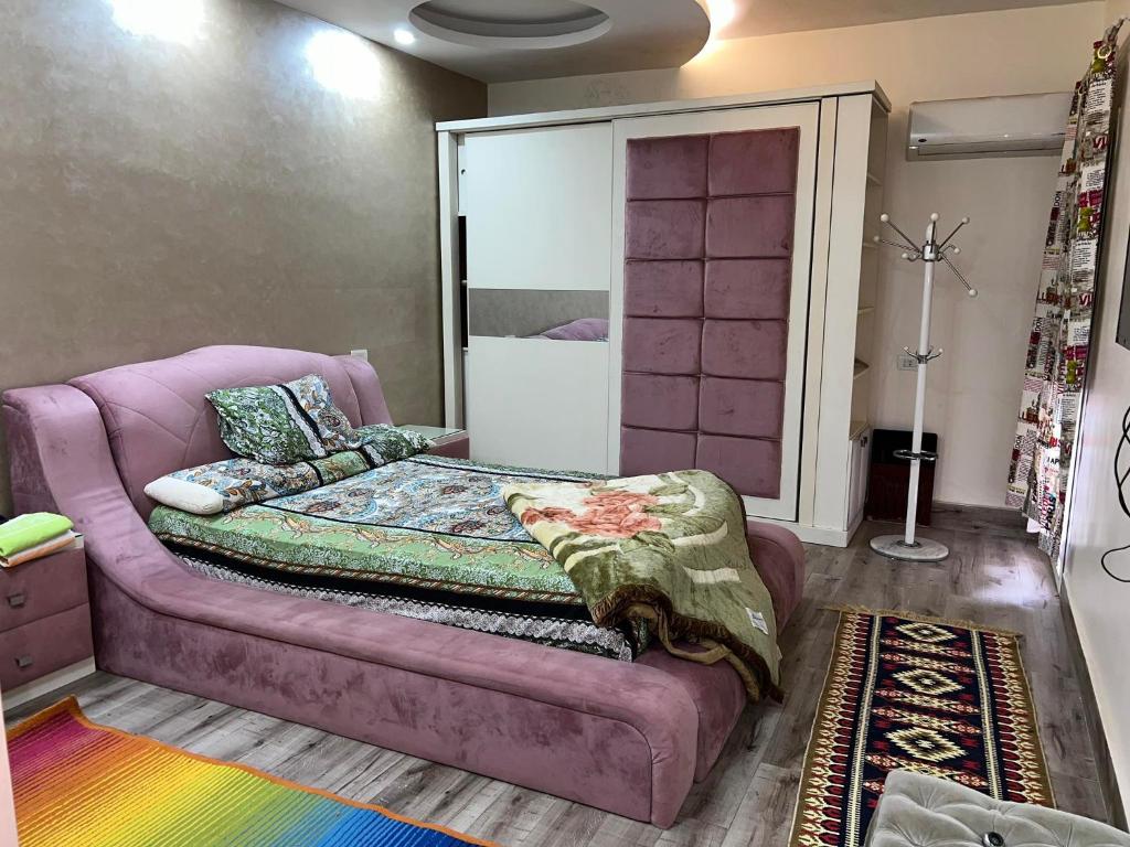 een paarse bank in een kamer met een bed bij احمد عرابي المهندسين in Caïro