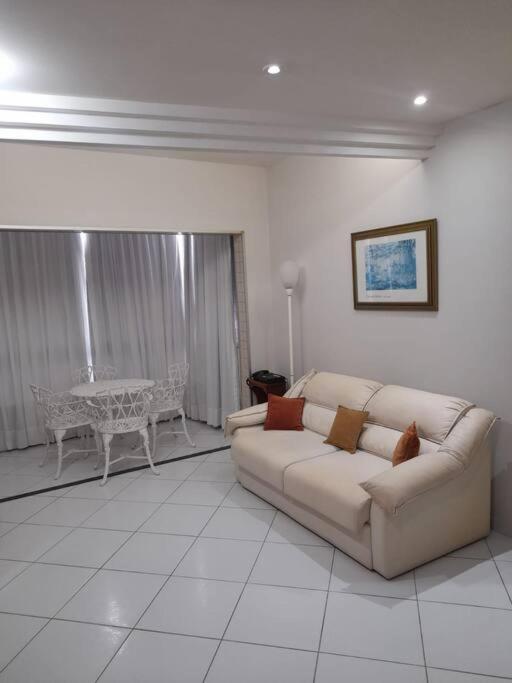 a living room with a couch and a table at Apart na Praia do canto in Vitória