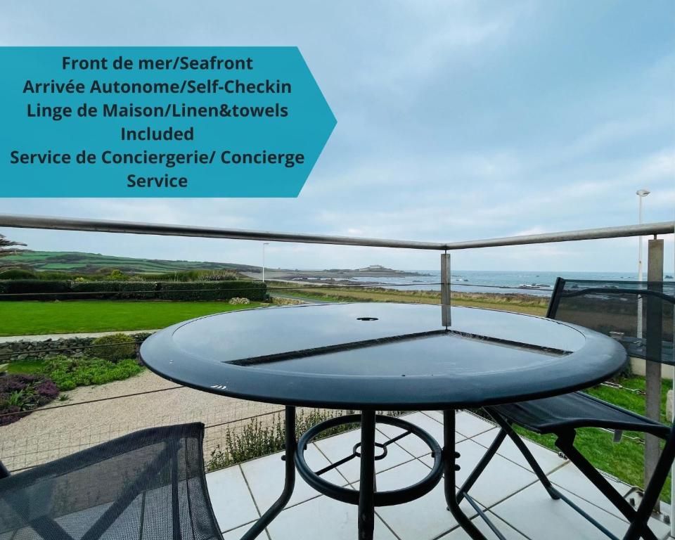 - une table sur un balcon avec vue sur l'océan dans l'établissement Beach House 50, à Omonville-la-Rogue