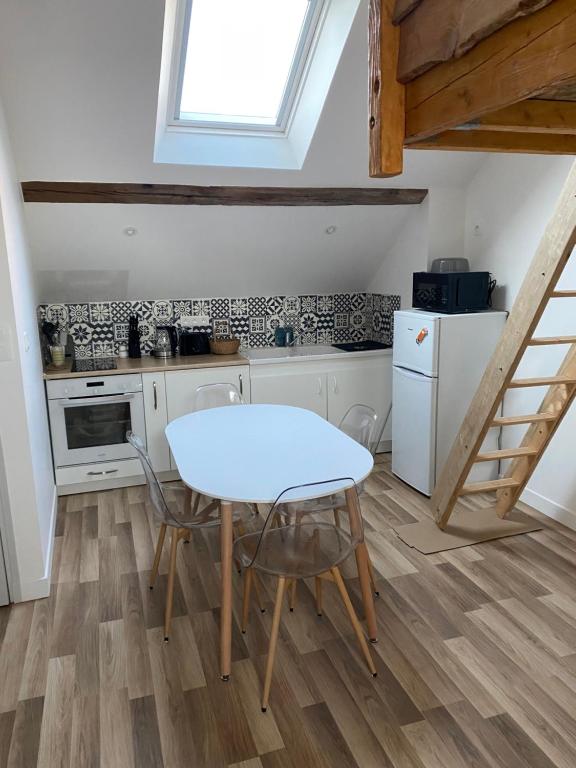 cocina con mesa y sillas en una habitación en Charmant studio sous combles, en Aubigny-sur-Nère