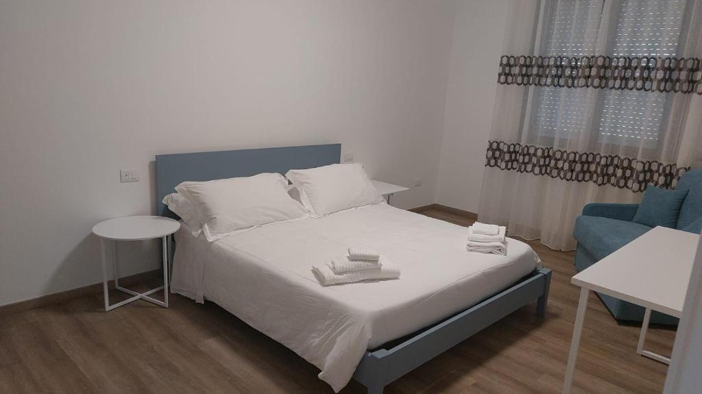ein kleines Schlafzimmer mit einem Bett und einem blauen Stuhl in der Unterkunft Welcome Appartamenti in Matera