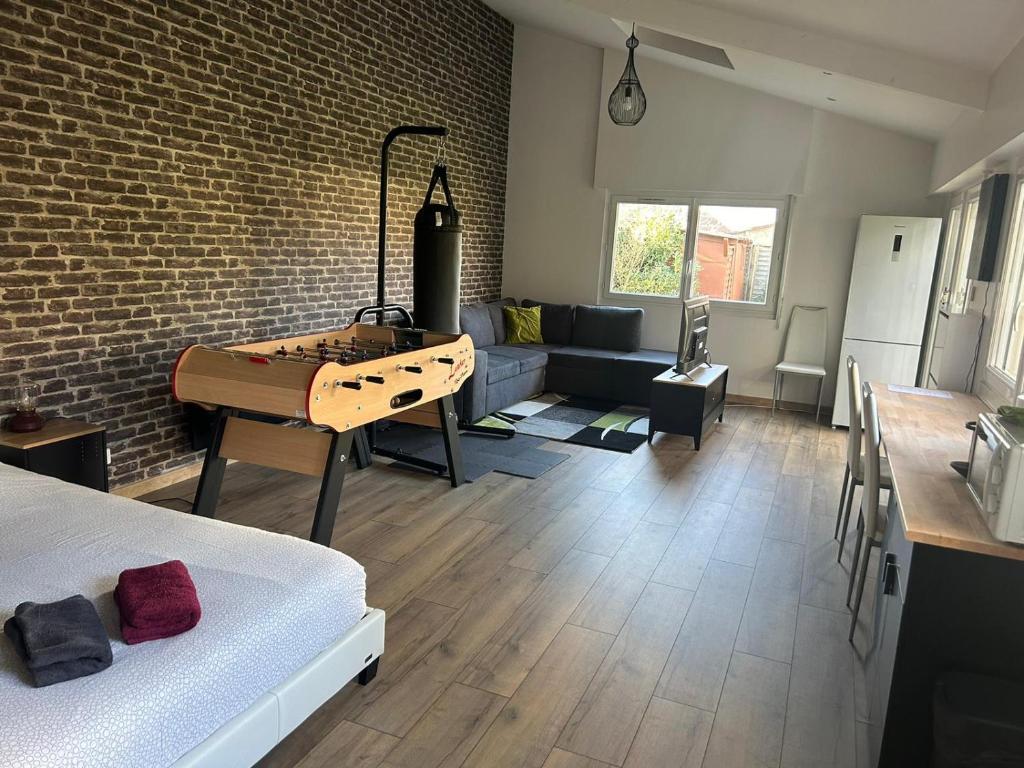 a living room with a bed and a table in a room at Un bol d'air frais près de Paris in Eaubonne