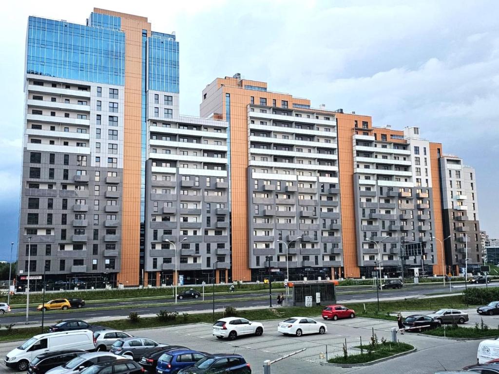 a parking lot with cars parked in front of tall buildings at Panorama Zamkowe 5 in Rzeszów