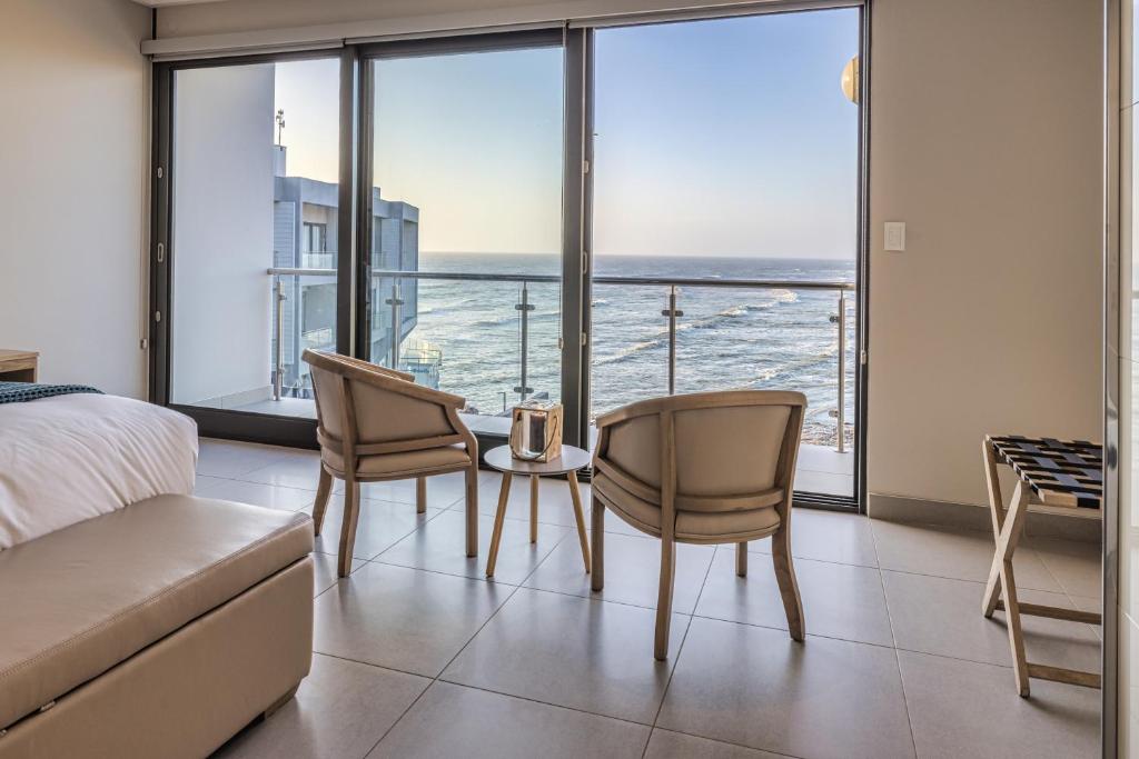 a bedroom with a bed and a table and chairs at Seafront Condo at The Pier 25 in Swakopmund