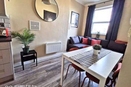 uma sala de estar com uma mesa e um sofá em Cosy Apartment near OConnell ST RELIABLE FAST WIFI em Dublin
