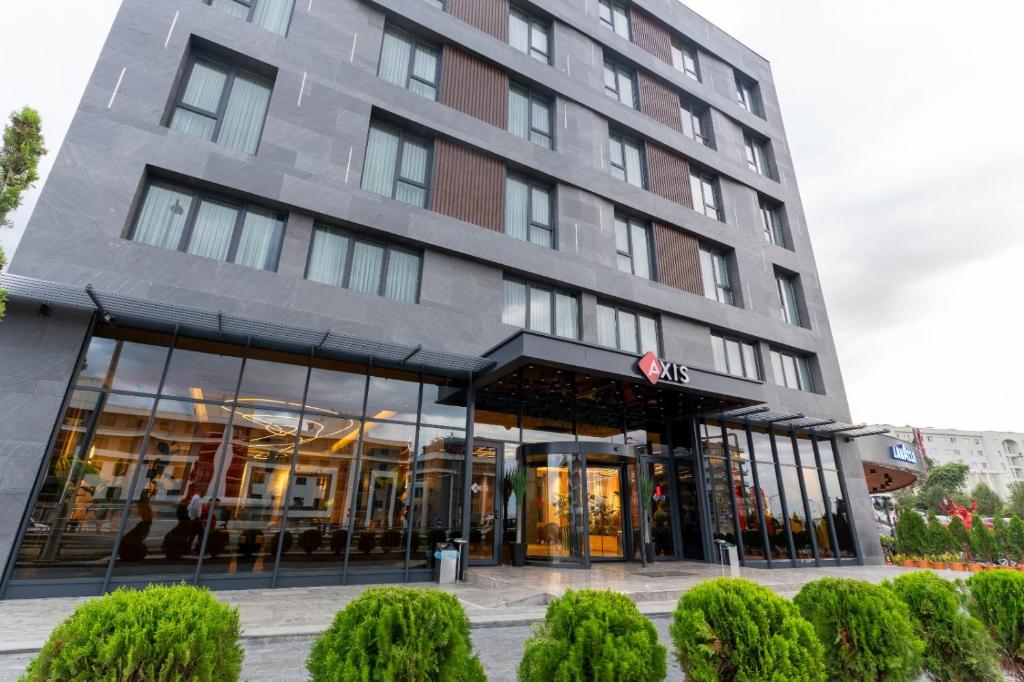 ein hohes Gebäude mit Glasfenstern davor in der Unterkunft Axis Hotel in Cimenli