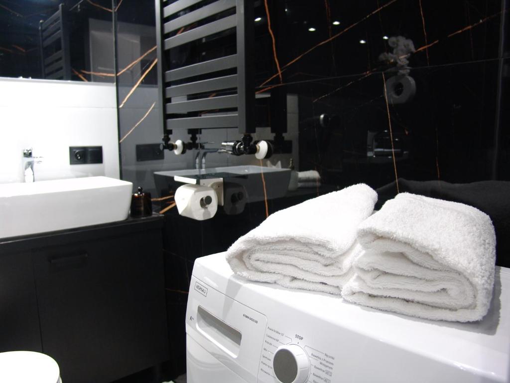 a washing machine with towels on top of it in a bathroom at ZB Apartment GREY Bytom Centrum Piekary Sląskie Siemianowice Chorzów in Bytom