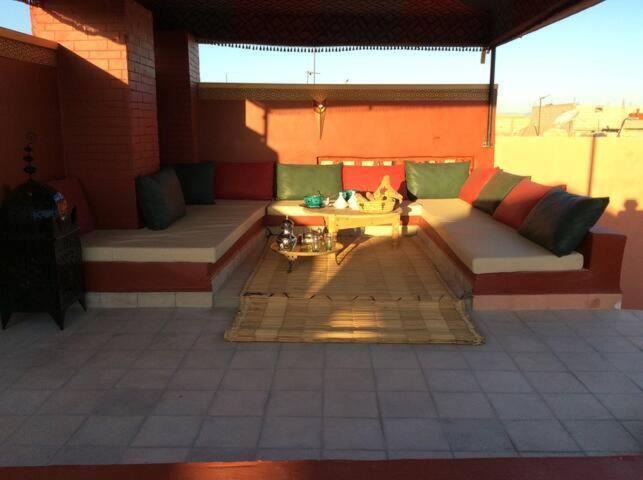 een patio met een bank en een tafel in een gebouw bij Chez Zohra in Taroudant