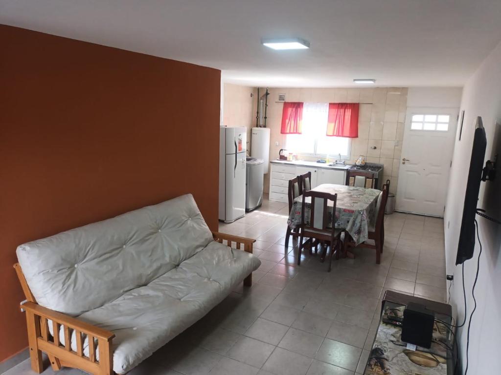 uma sala de estar com um sofá e uma cozinha com uma mesa em Lo de fernando 3 em Río Gallegos