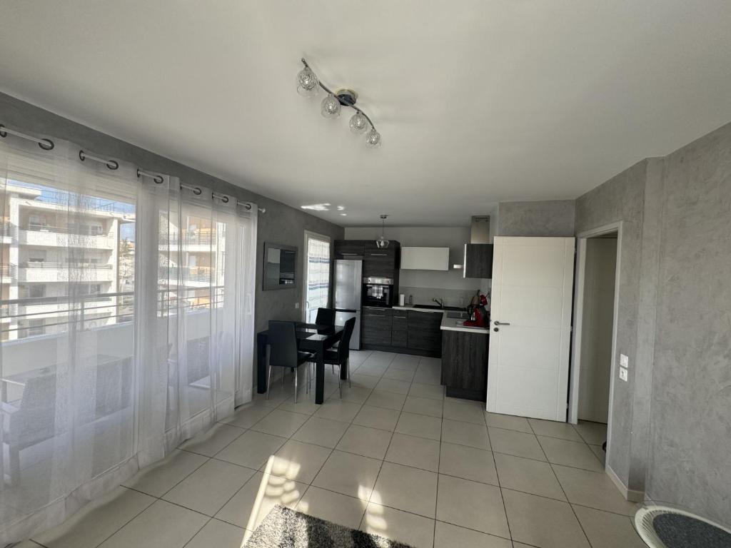 a living room with a kitchen and a dining room at Appartement de Romain in Annecy