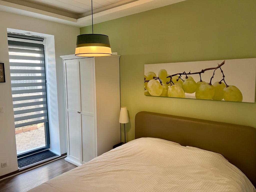 a bedroom with a bed and a painting of fruit at De Tussenstop in Villefranche-sur-Saône