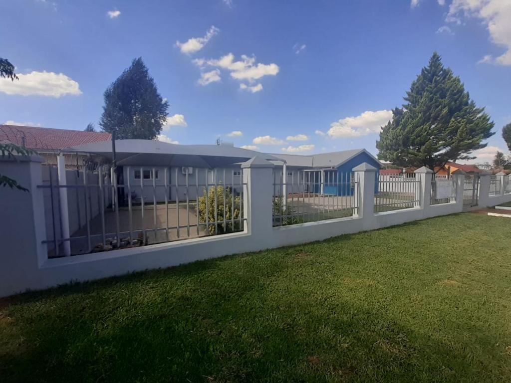 una cerca blanca en un patio con césped en Resting Place @ 89, en Bloemfontein