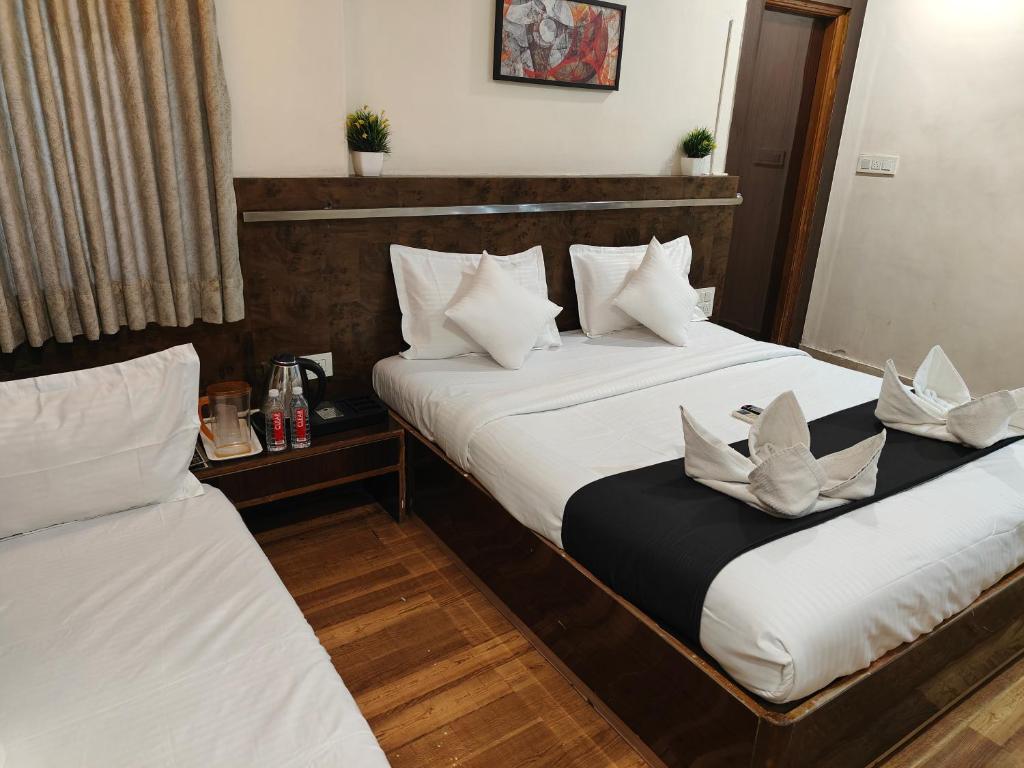 Postel nebo postele na pokoji v ubytování Kiara Shirdi Park Inn