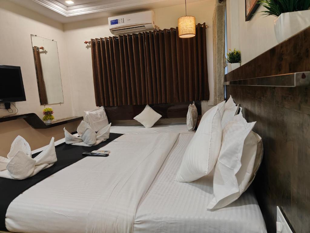 Postel nebo postele na pokoji v ubytování Kiara Shirdi Park Inn