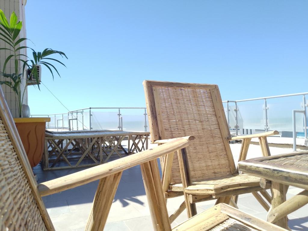 Appartement Yoff Virage vue panoramique sur mer في داكار: زوج من الكراسي وطاولة على شرفة