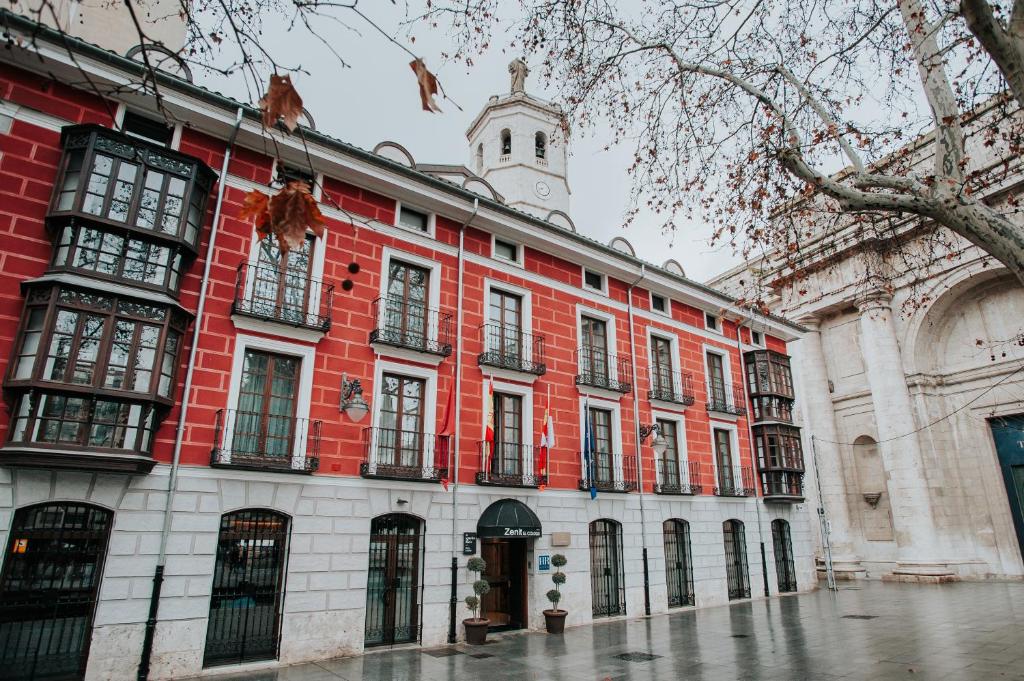 un edificio rosso e bianco con torre dell'orologio di Zenit El Coloquio a Valladolid