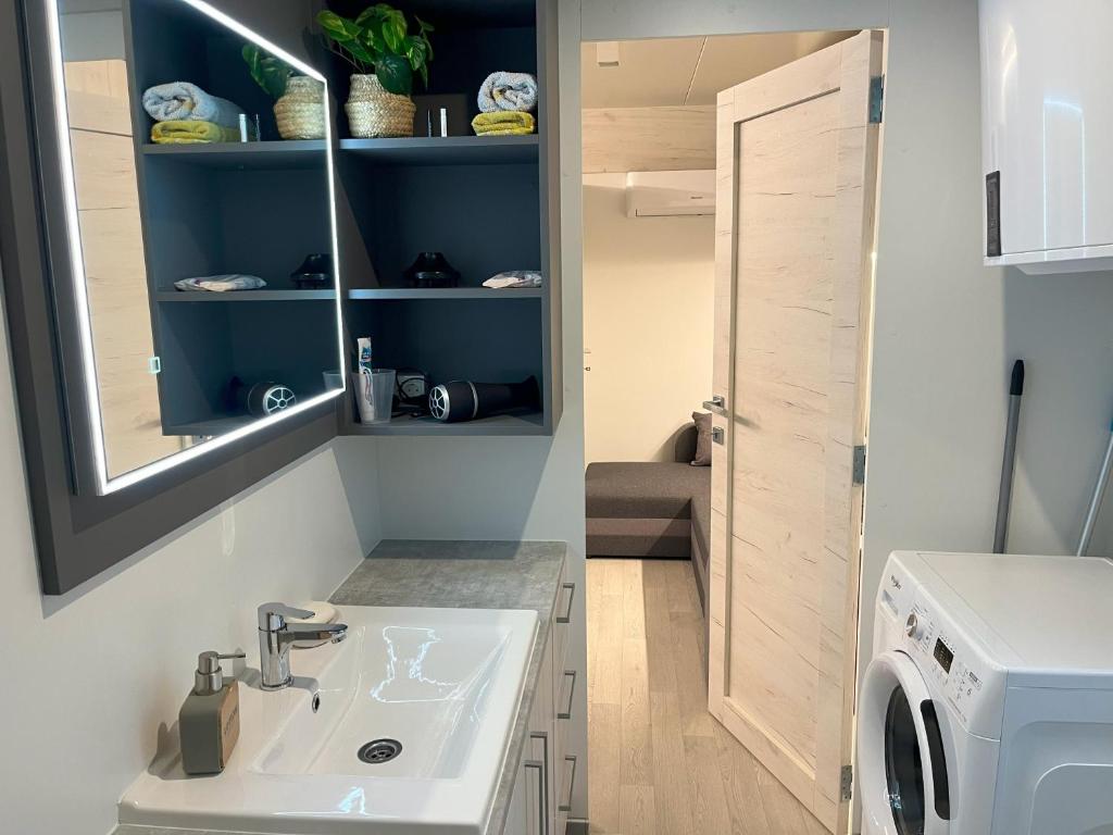 ein Badezimmer mit einem Waschbecken und einer Waschmaschine in der Unterkunft Getaway Mobile Home in Drage