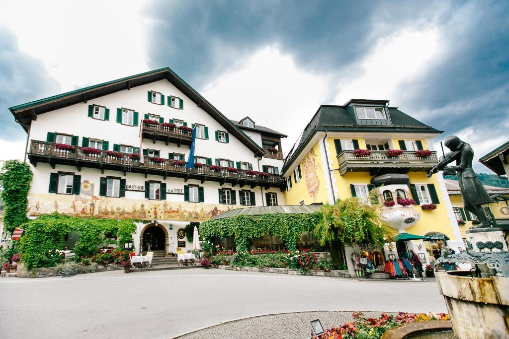a large building with a courtyard in front of it at Hotel Gasthof zur Post in Sankt Gilgen