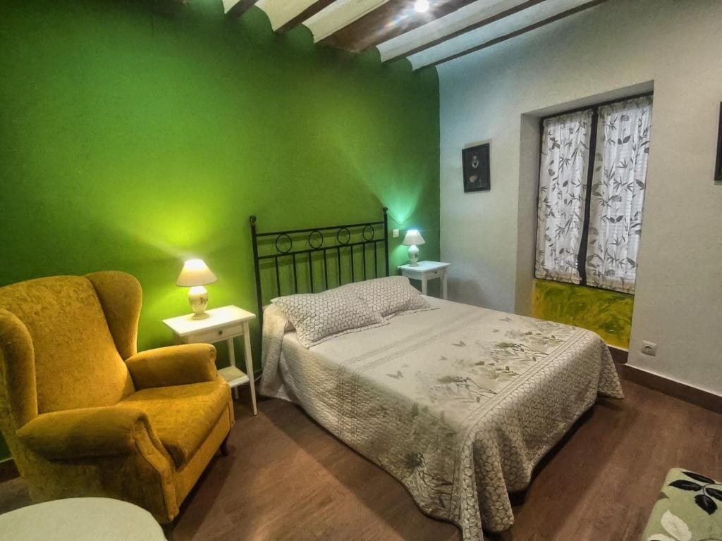 1 dormitorio verde con 1 cama y 1 silla en Las Violetas, en Villanueva de los Infantes