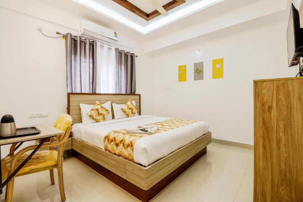 a bedroom with a bed and a table and a desk at THE MARELLA SUITES in Bangalore